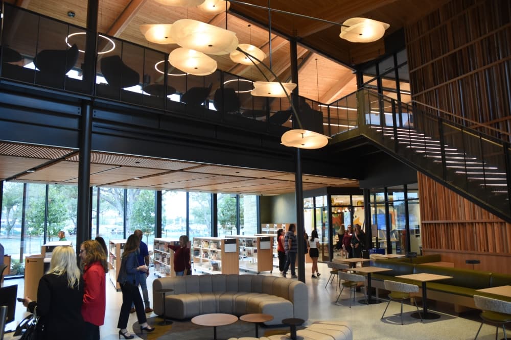 Couches, sitting areas and tables fill the lobby area of the library. 