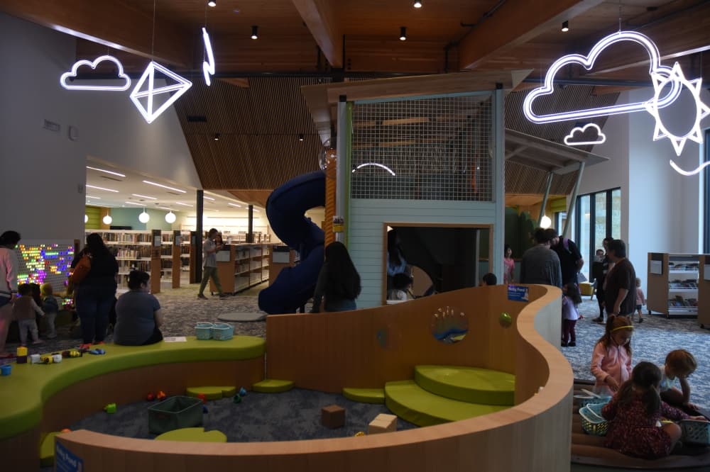 A sitting area in the front of the image gives way to a box type structure with a swirling slide coming out of it. 