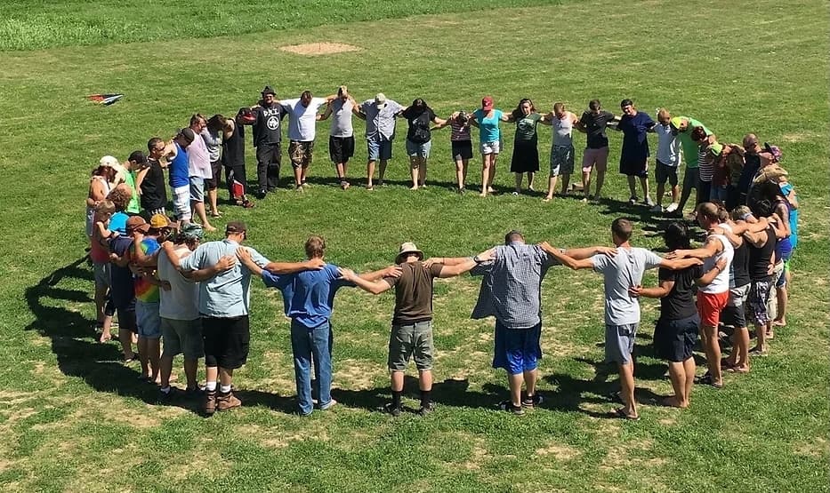 A group stands in a circle and prays.