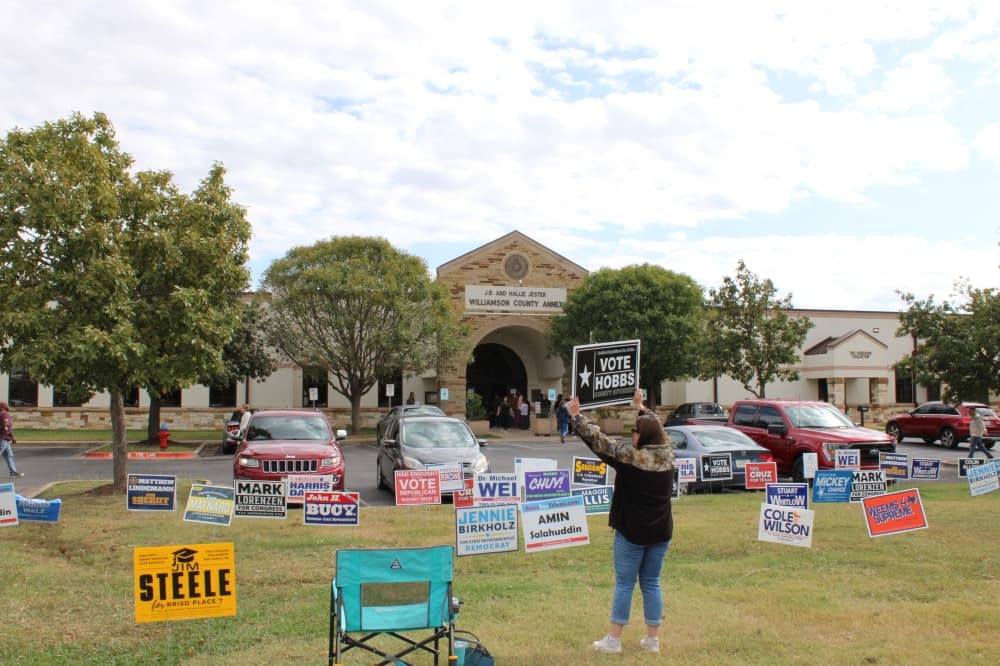 In front of the Williamson County Jester Annex on Election Day, a woman holds a sign reading 'Vote Hobbs,' the Republican candidate for county attorney, who received the majority of votes given election results. (Anna Maness/Community Impact) 
