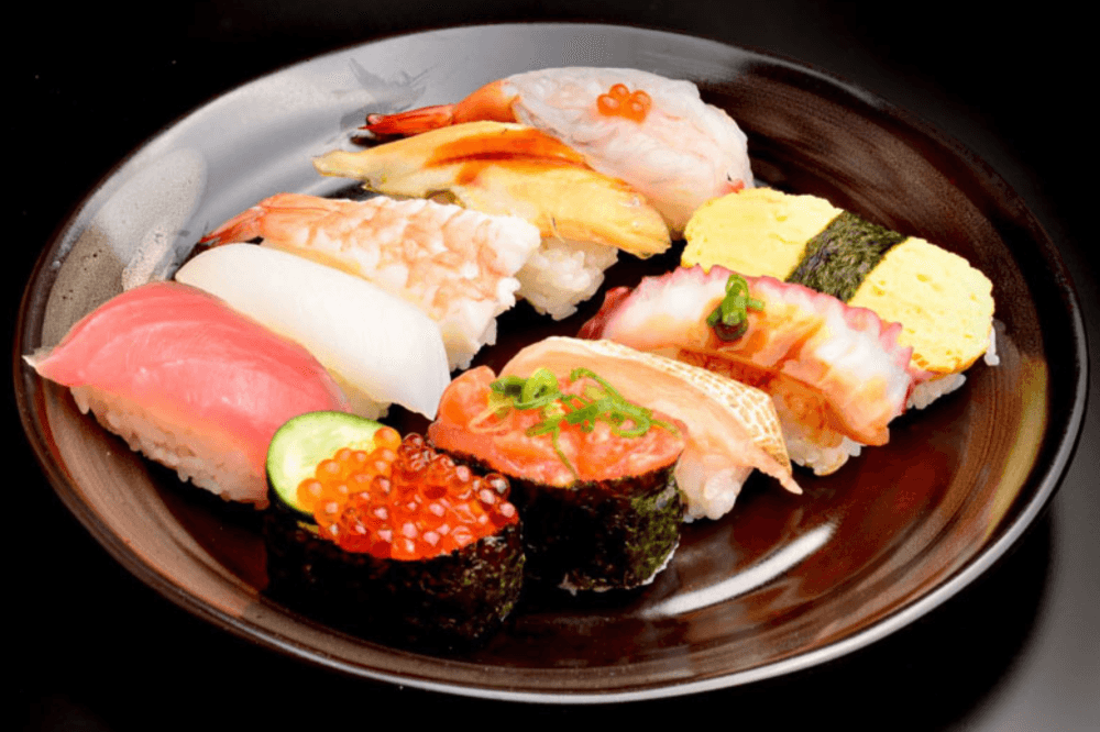 A plate of different sushi and sashimi is shown.