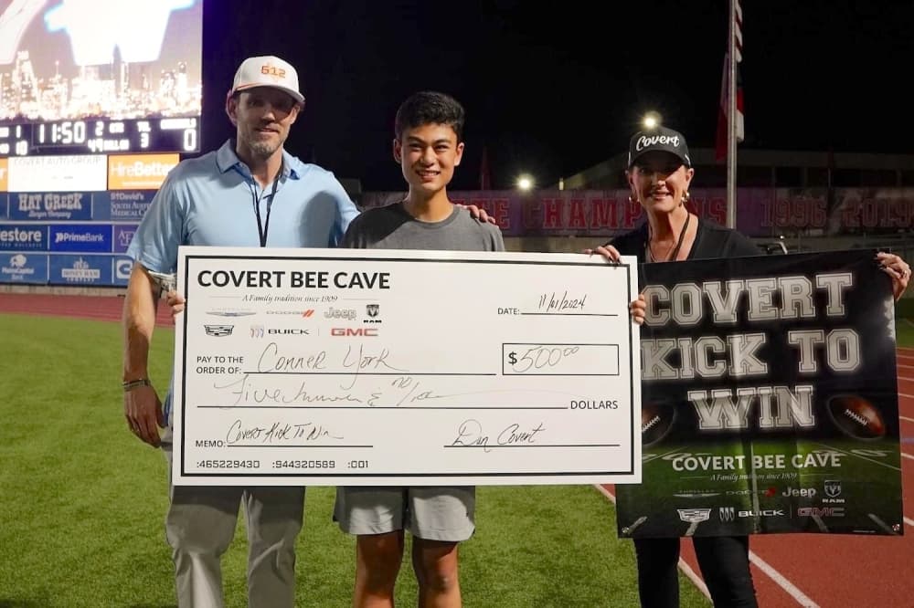 kid standing with $500 check