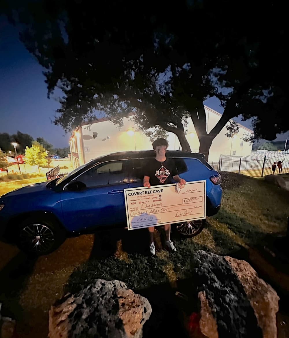 kid standing with $1,000 check