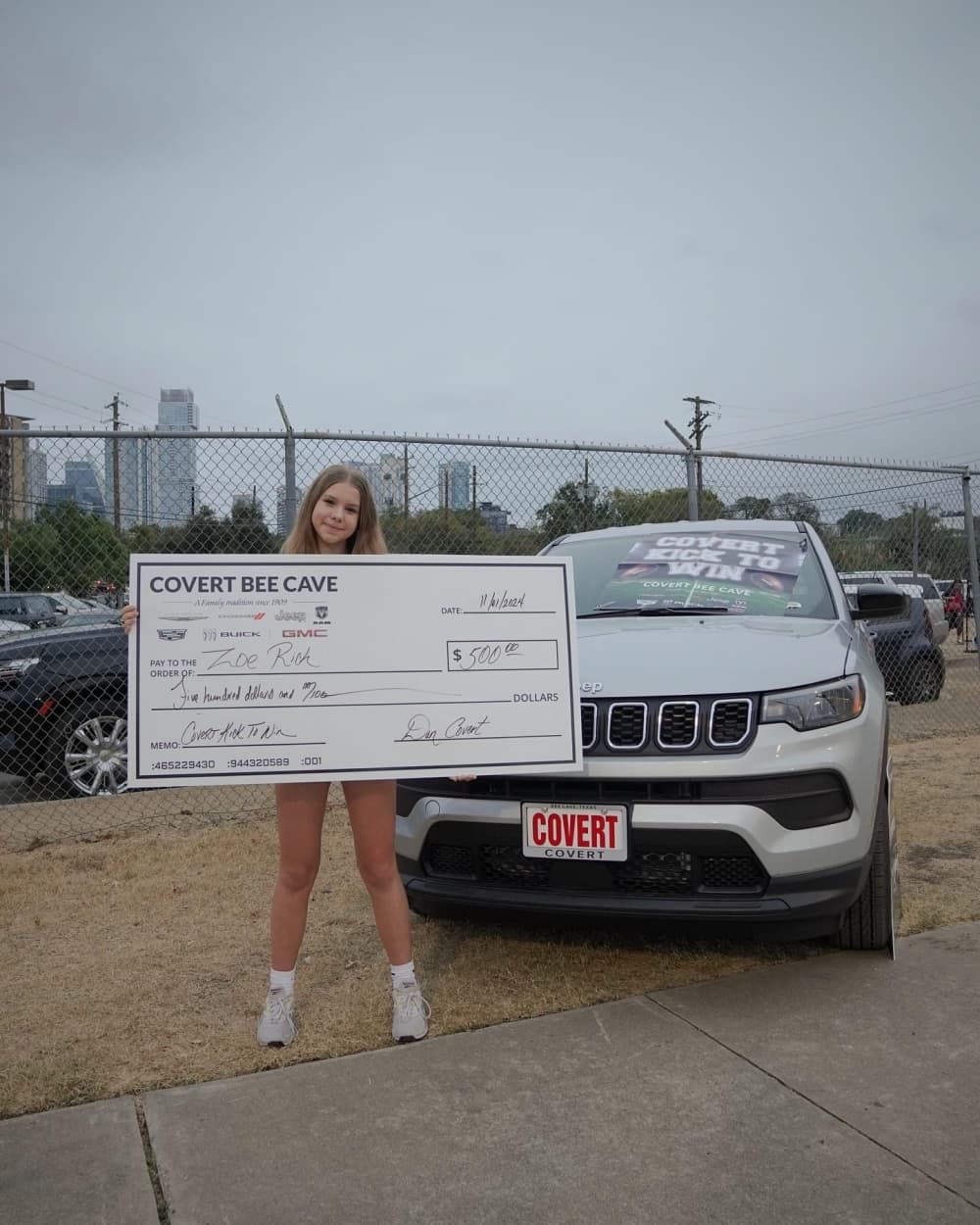 kid standing with $500 check