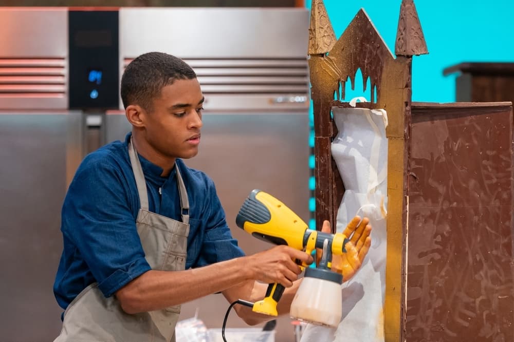 Conner is shown building a cake.