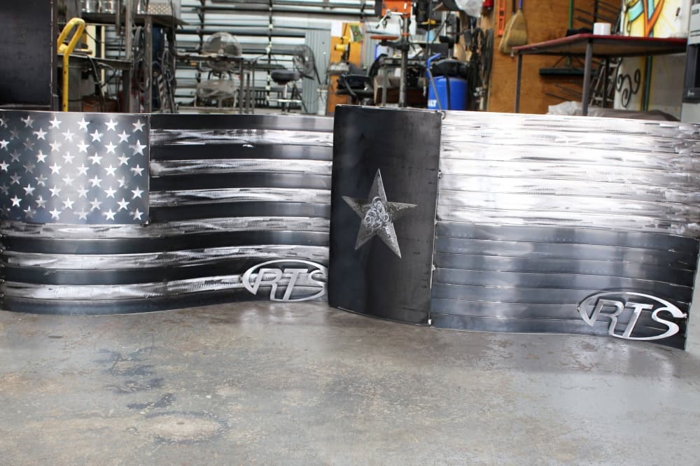 American and Texas flag made of metal with business logo in bottom right corner. 