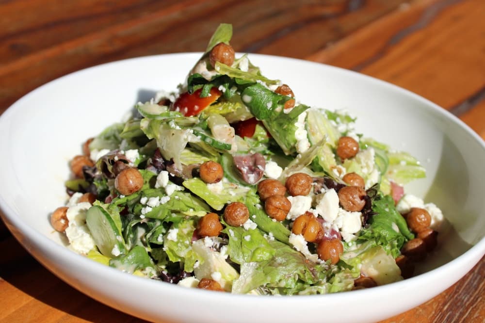 Salad with chickpeas and dressing on top. 