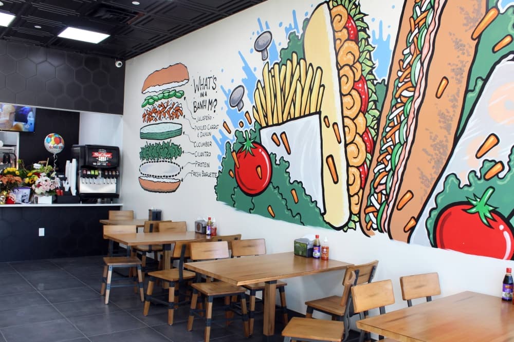 Interior of restaurant with mural of food. 