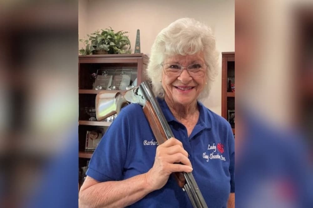 A woman holds a rifle