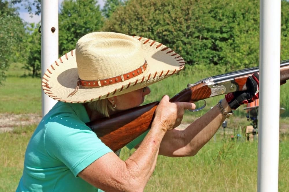 A woman aims a rifle