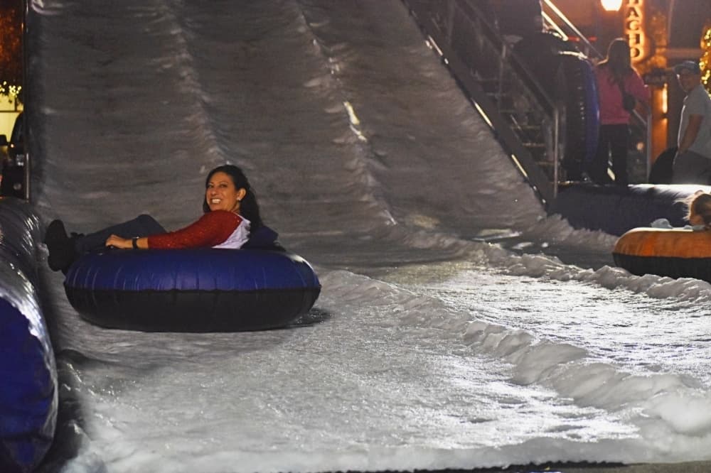 person riding a tube down a hill of snow 