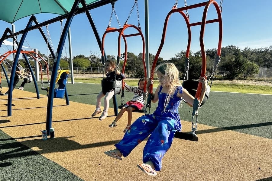 The playground includes a shade covering, swings, a TriRunner swing, a padded ground cushion for safety and more. (Thalia Guzman/Community Impact)