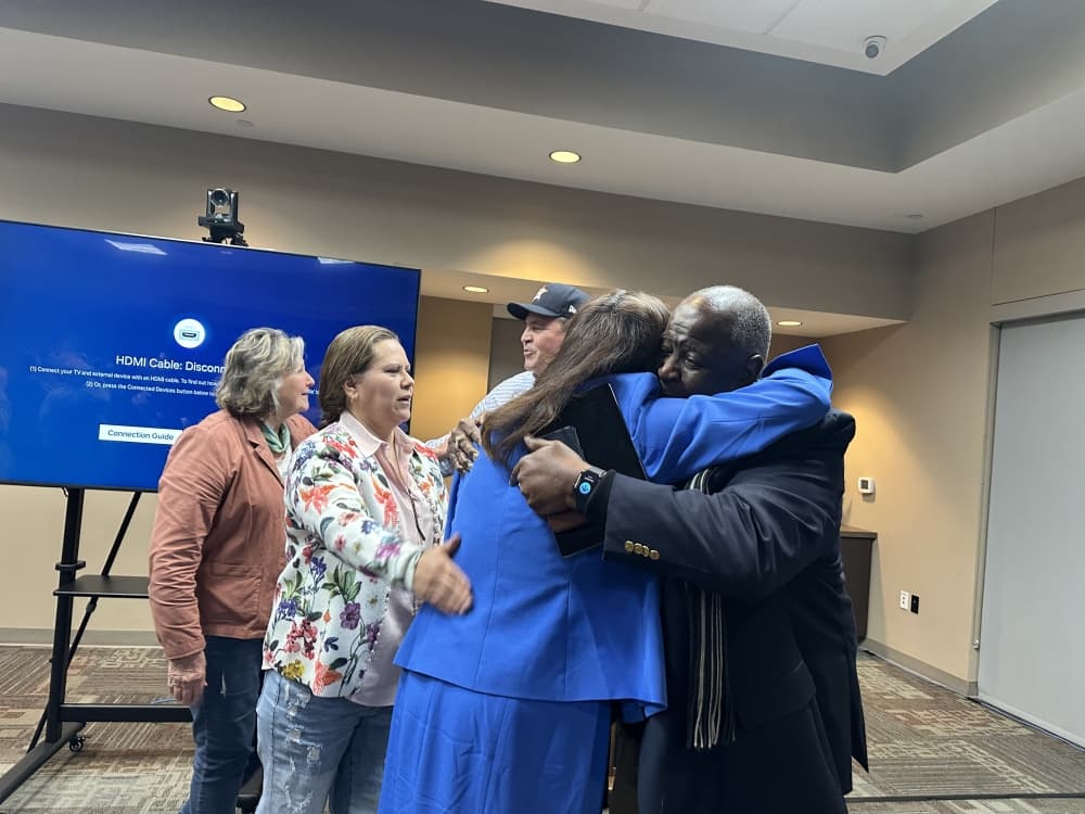 People are shown embracing Sylvia after the meeting.