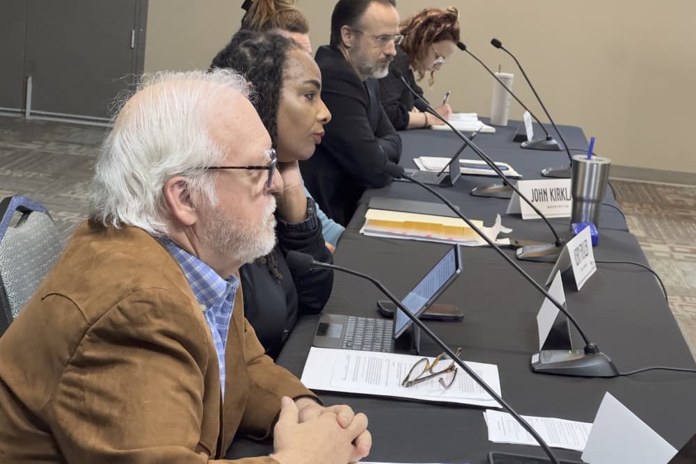 Lyle Nelson and Cheryl Lee are shown in the foreground during the meeting.