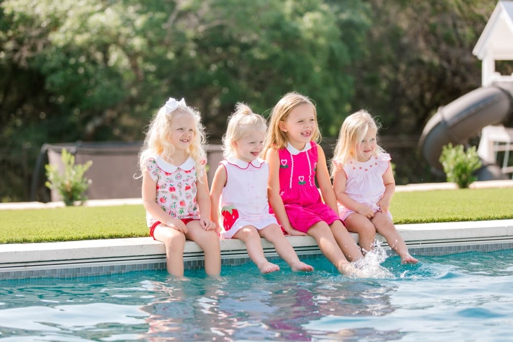 4 girls at edge of swimming pool