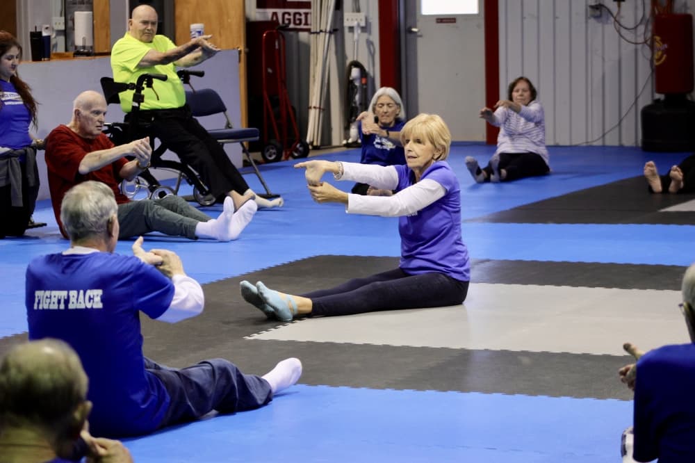 Rock Steady Boxing Coach Marilyn Renken leads a stretching session during a class on December 2, 2024