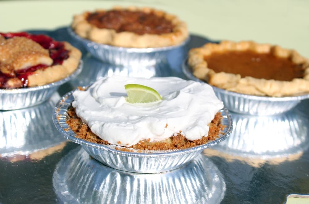 Four small pies in tin pie pans.