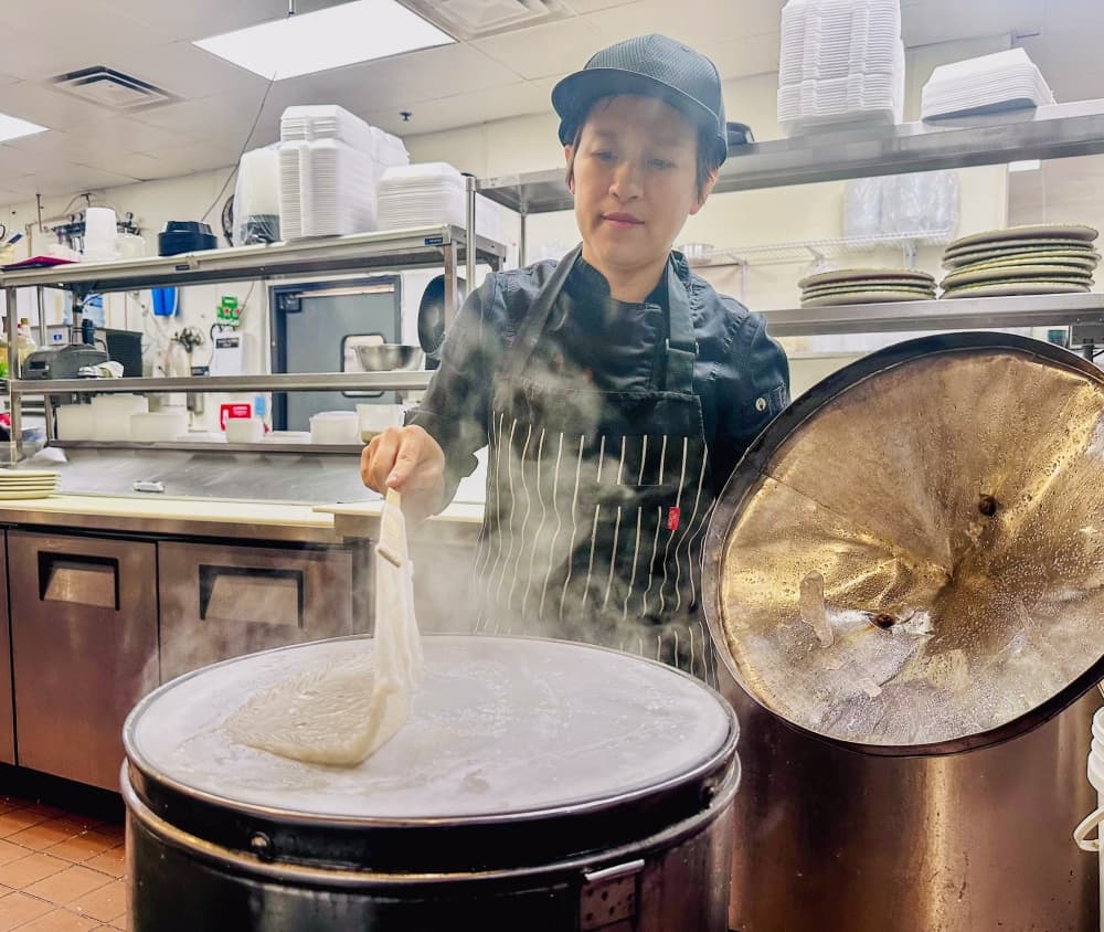 An image of the owner of the restaurant cooking a dish. 