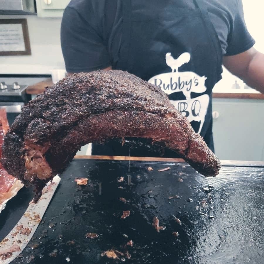 The owner holds up a brisket and shows how flexible it is.