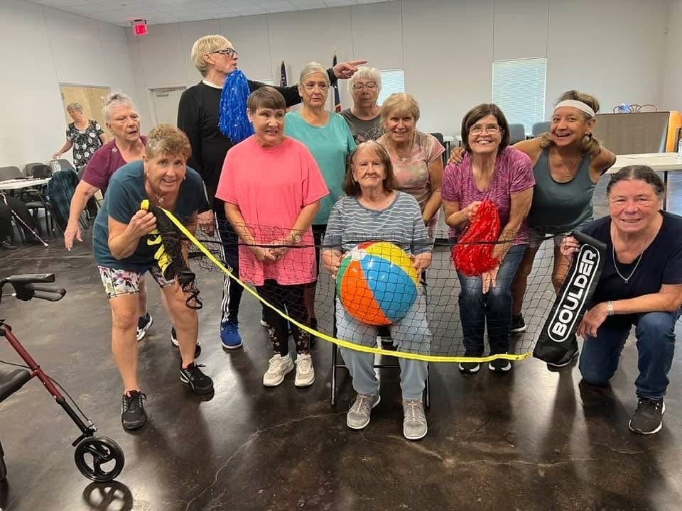 An image of seniors holding a volleyball net. 