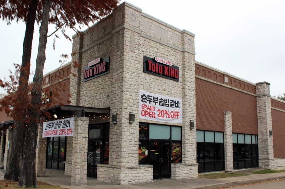 Exterior of building with Tofu King signage and now open banner on building. 
