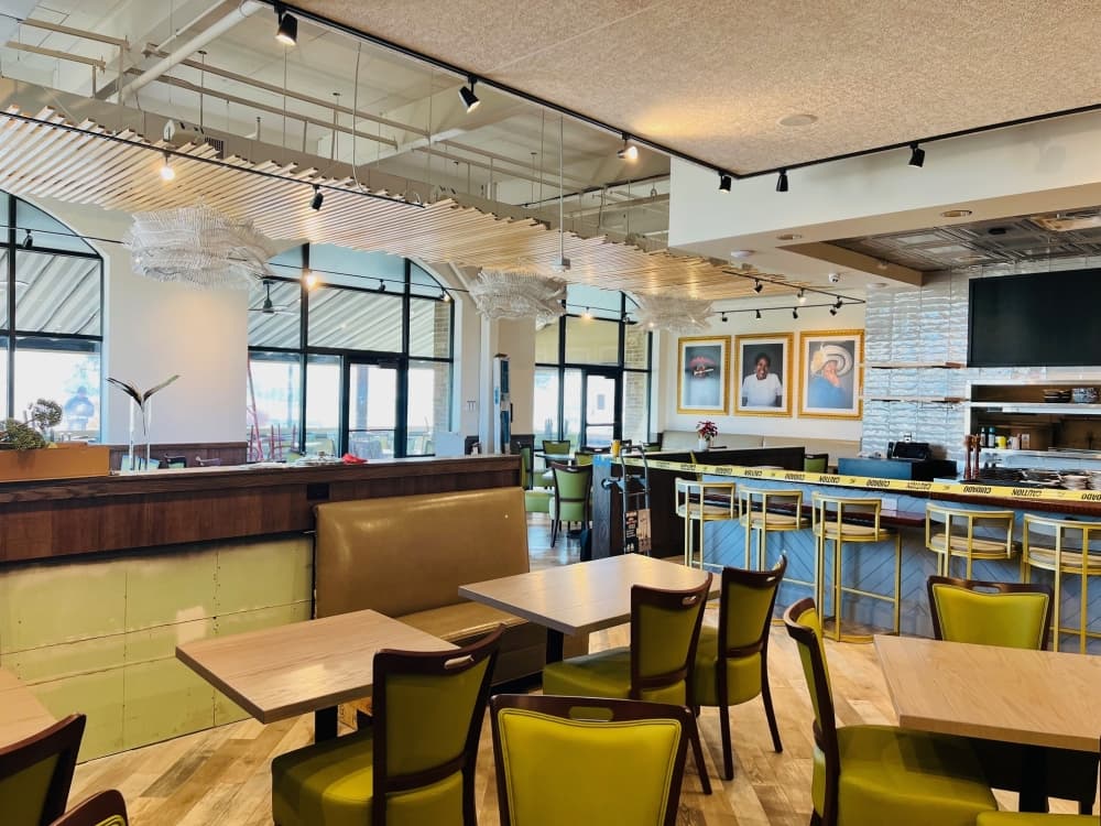 Interior of a restaurant with green, brown and white design elements. 