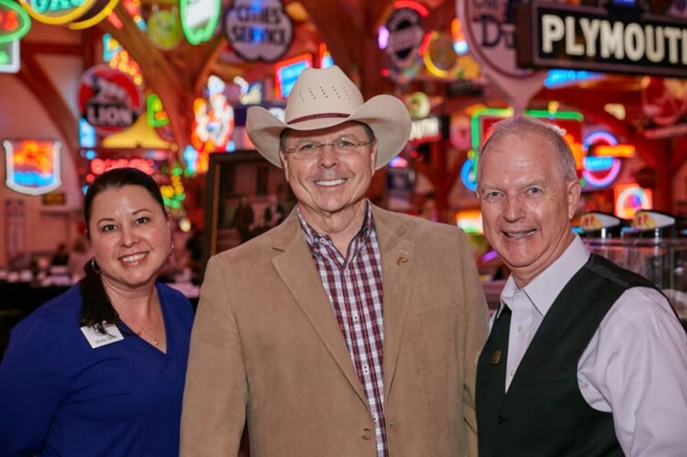 Three people pose at an event