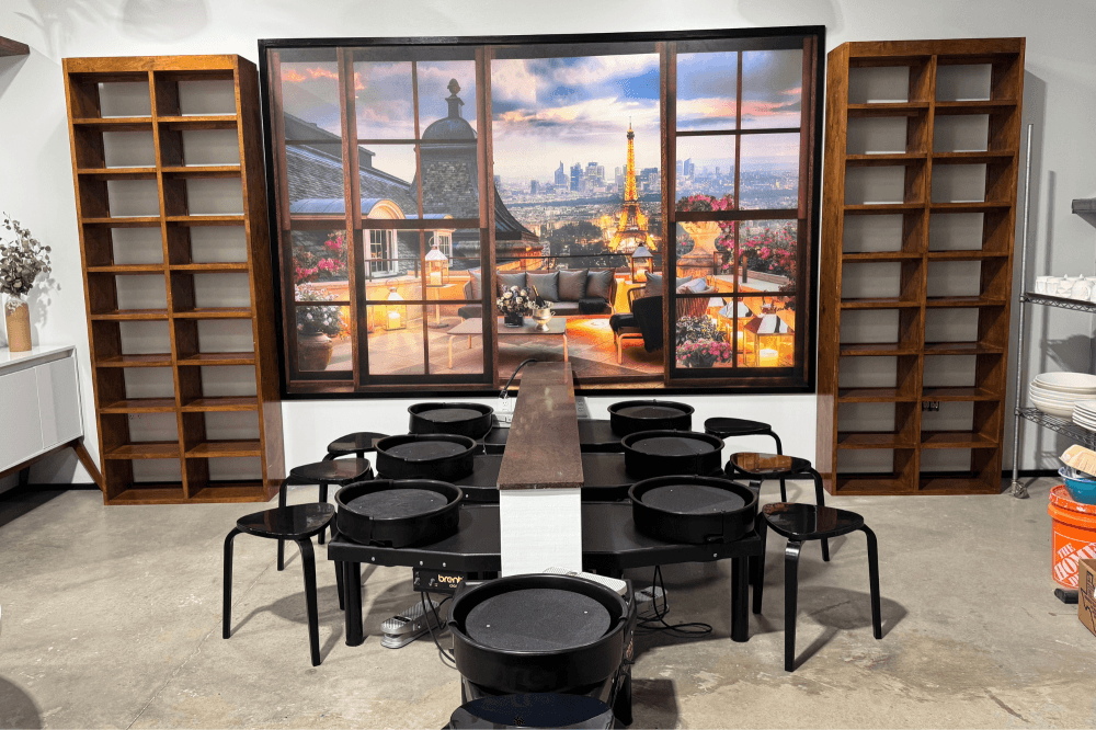 A table with many chairs is shown inside the studio.