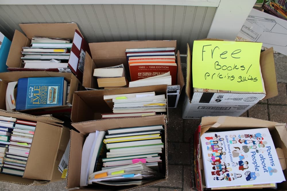 Books in cardboard boxes are placed outside of a closed store. 
