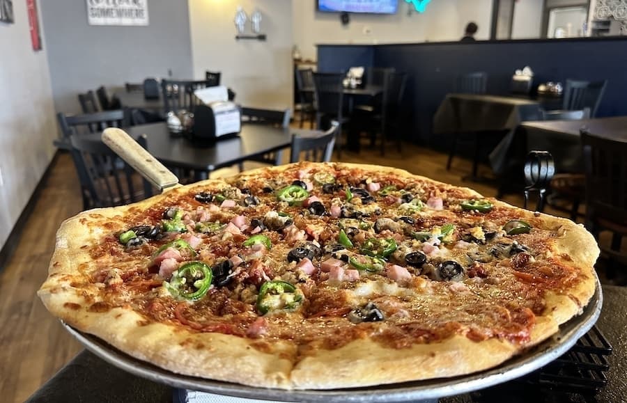 The Butcher Shop specialty pizza ($23.99) is topped with pepperoni, Italian sausage, ham, bacon, fresh garlic, jalapenos and mozzarella cheese. (Thalia Guzman/Community Impact)