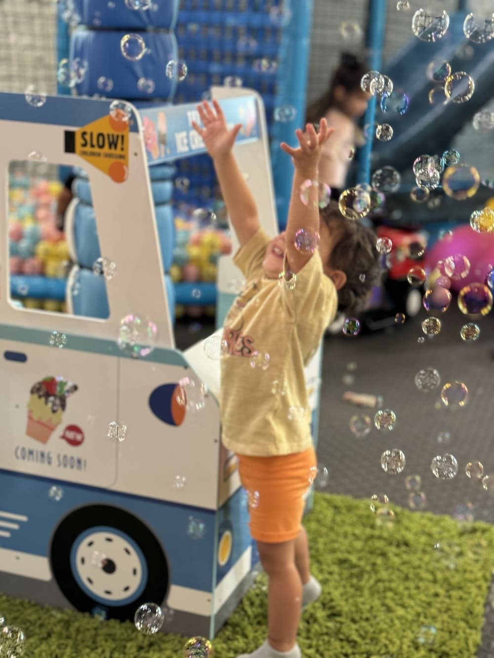 An image of a child playing with bubbles inside the business. 