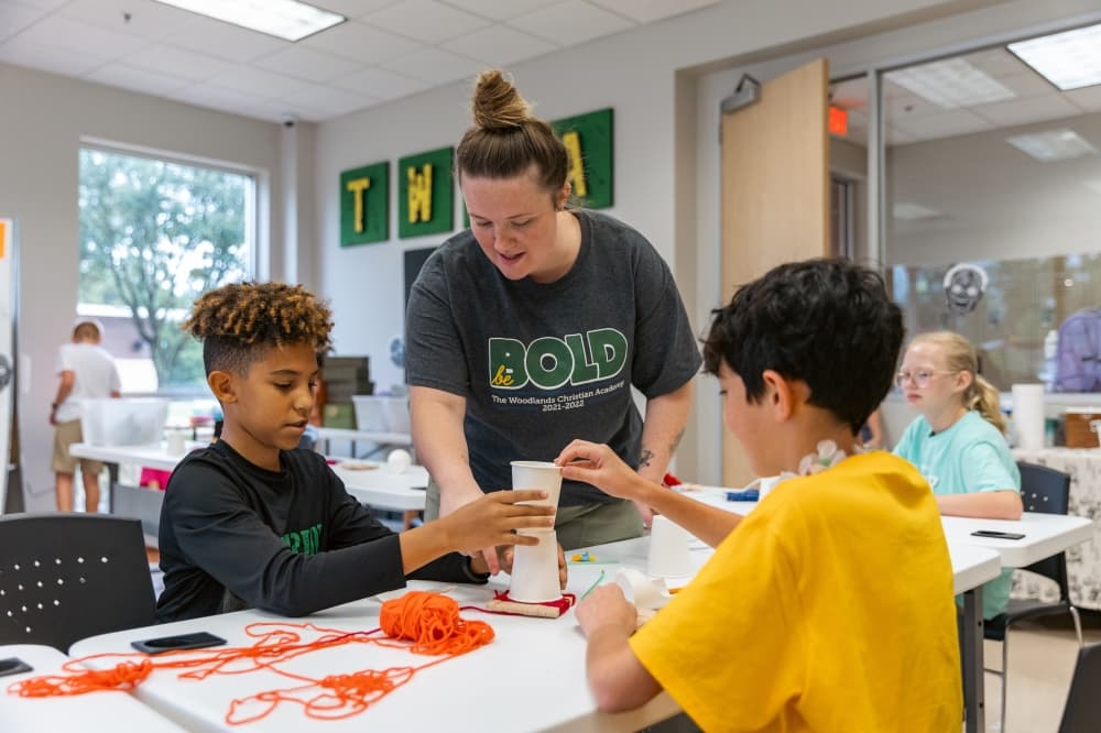 teacher helping students with STEM activity 