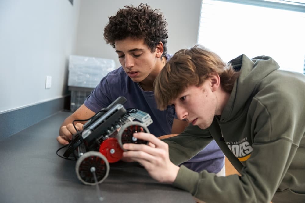 high school boys working on robotics project 