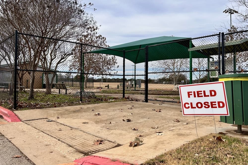 An exterior of a soccer field with a sign that says "field closed"