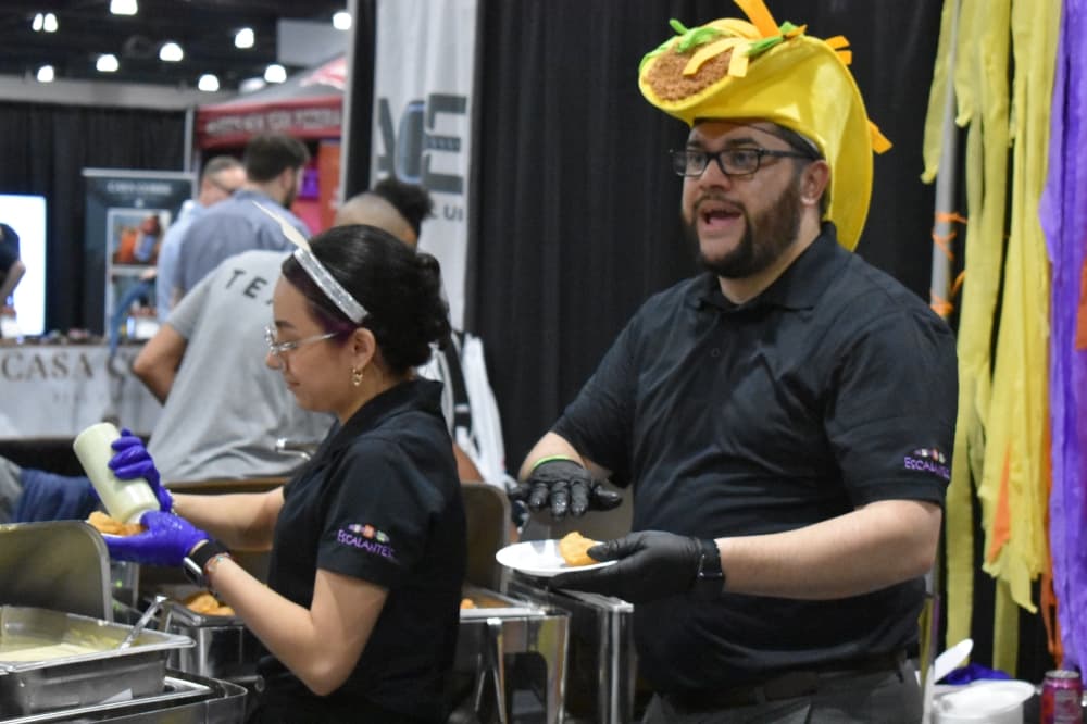 A man in a taco hat hands out food samples