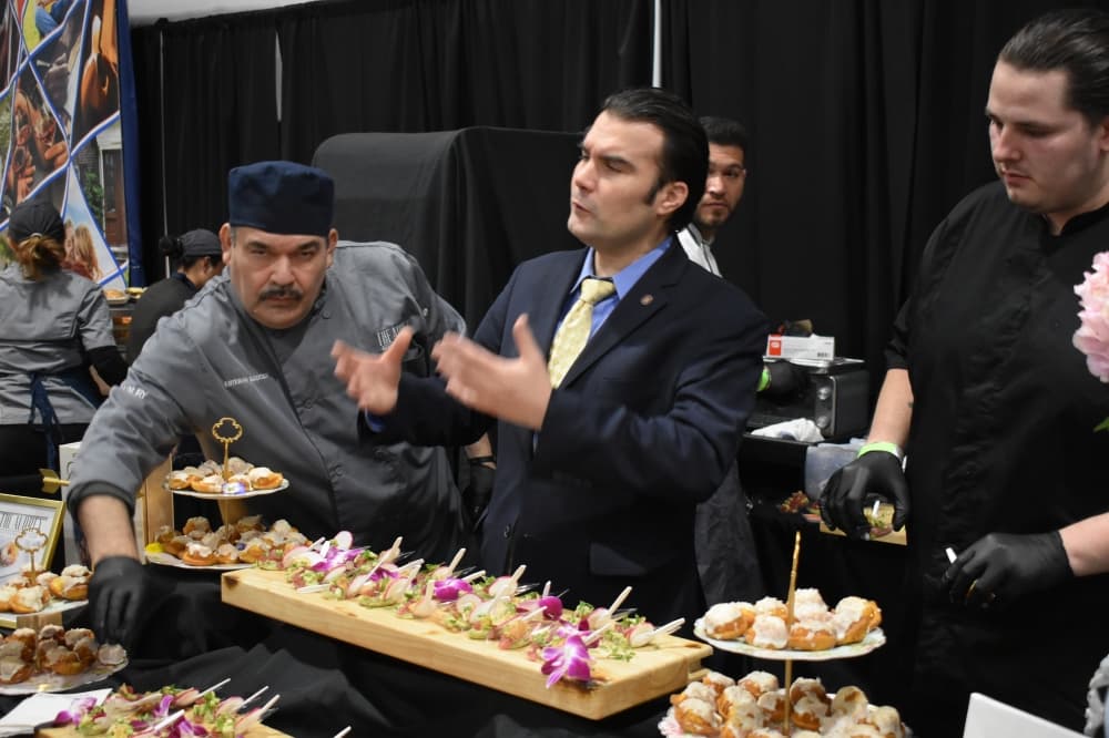 Two men arrange and speak about food samples