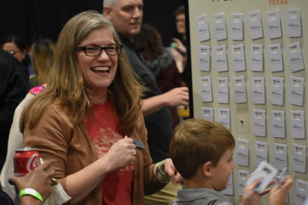 A woman laughs with a child and a matching game