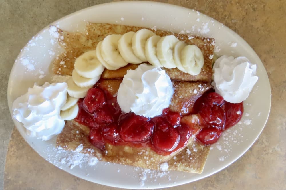 Menu staples include the cream-cheese filled WiscoTx crepes topped with whip cream, bananas and strawberries. (Jonathan Perriello/ Community Impact)