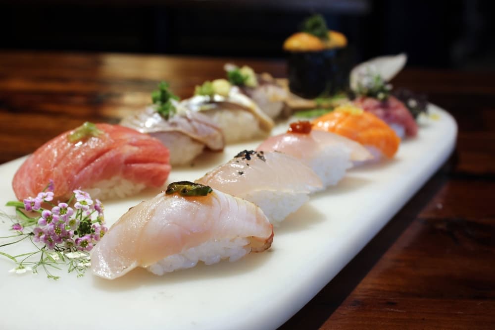 Various decorative sashimi pieces on a white plate. 