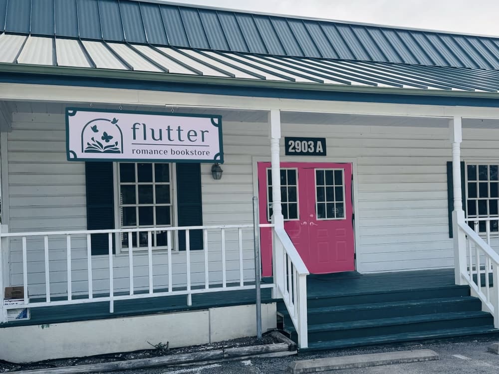 exterior shot of flutter romance bookstore building with sign 