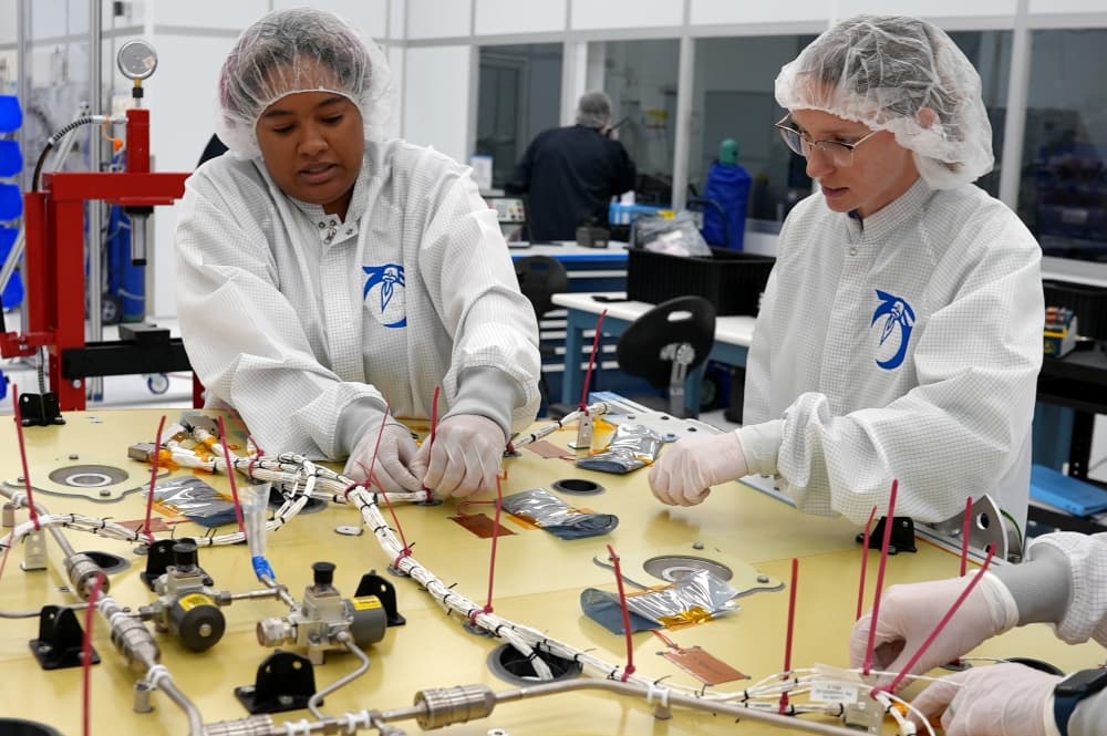 Workers putting together parts for a lunar lander.