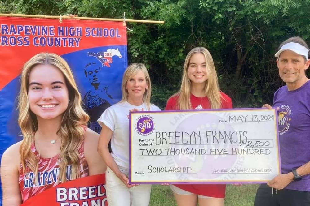 Three people holding an oversised $2,500 check. 