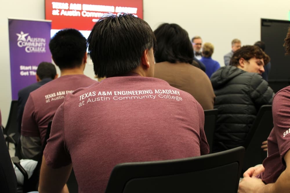An engineering student sits in a chair during a press conference. 