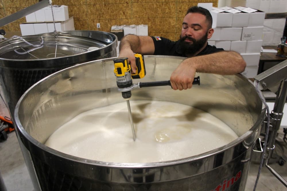 Owner Isaac Pruna mixing a batch of mead. (Amira Van Leeuwen/Community Impact)