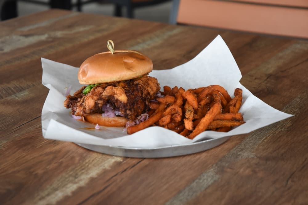 Float the River Brewing’s Nashville chicken sandwich ($17.00) is a heaping piece of fried chicken served in a spicy sauce. (Community Impact)
