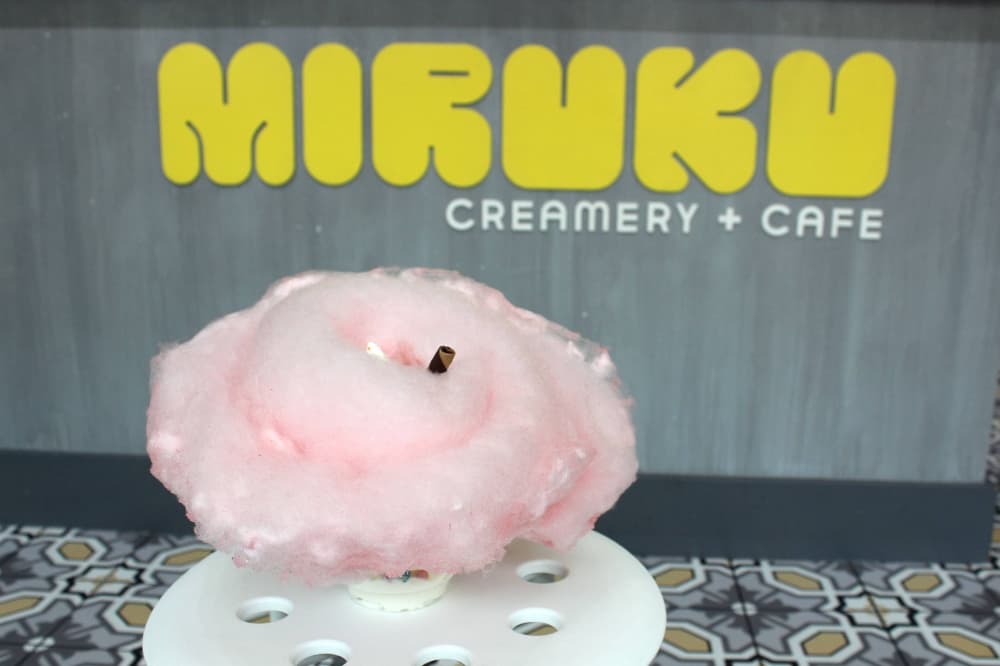 Cotton candy surrounding a straw in a cup. 