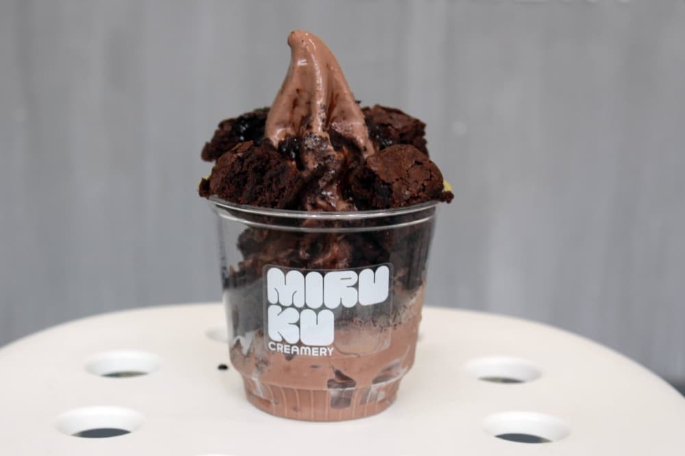 Chocolate ice cream with brownies and chocolate syrum  in a cup with Miruku branding.