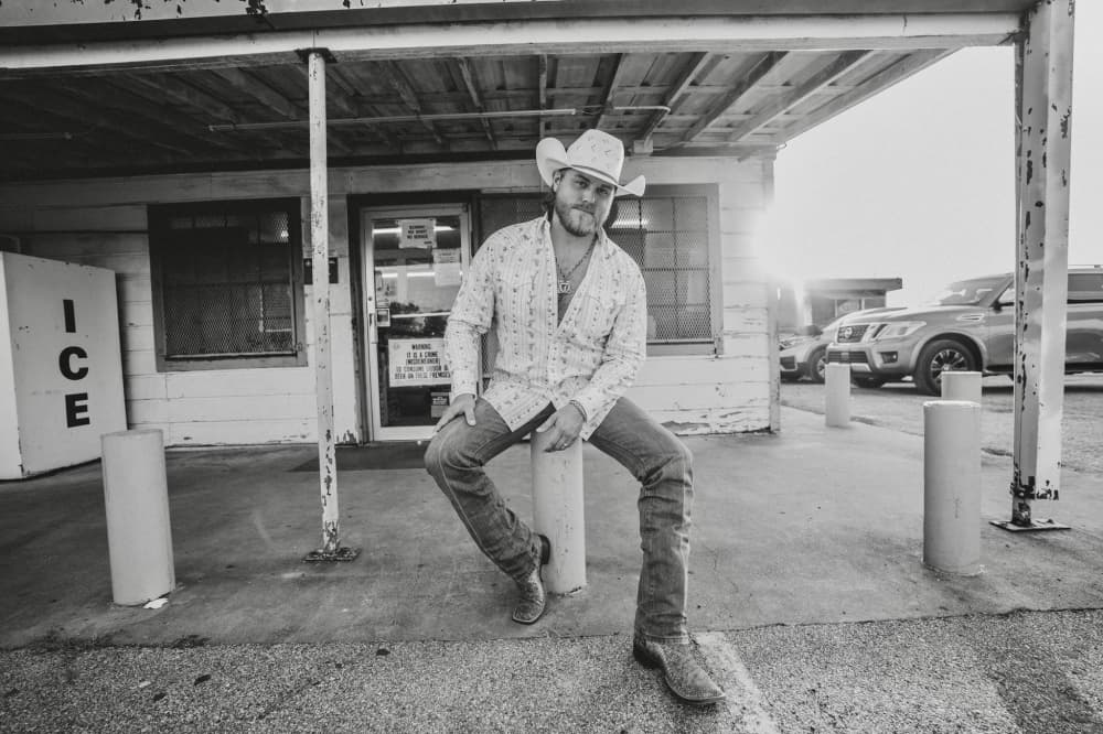 sitting man in cowboy hay