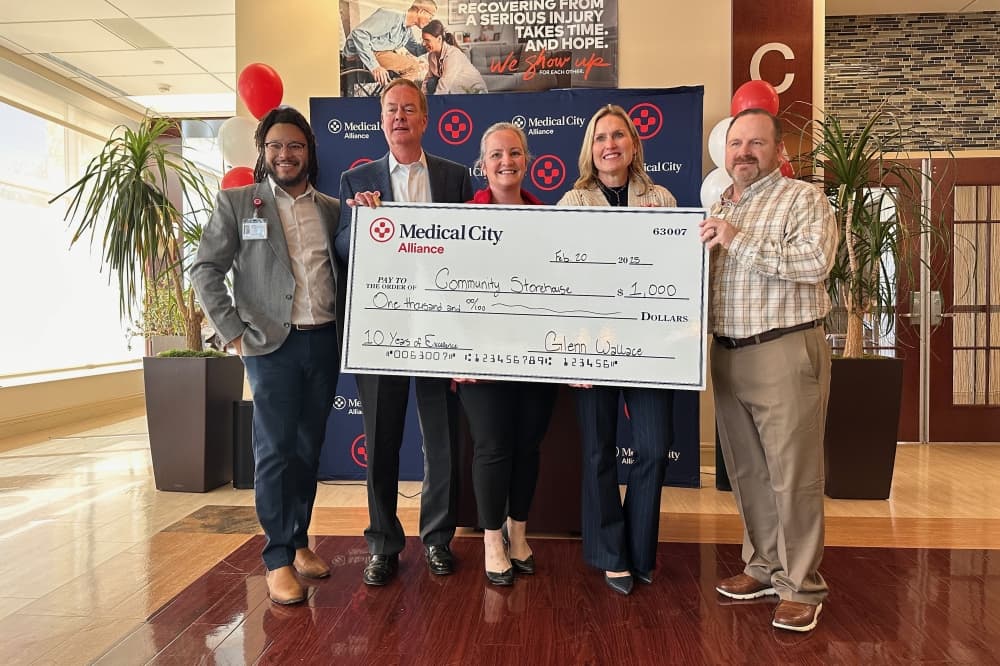 Medical City Staff and Community Storehouse pose with a large check