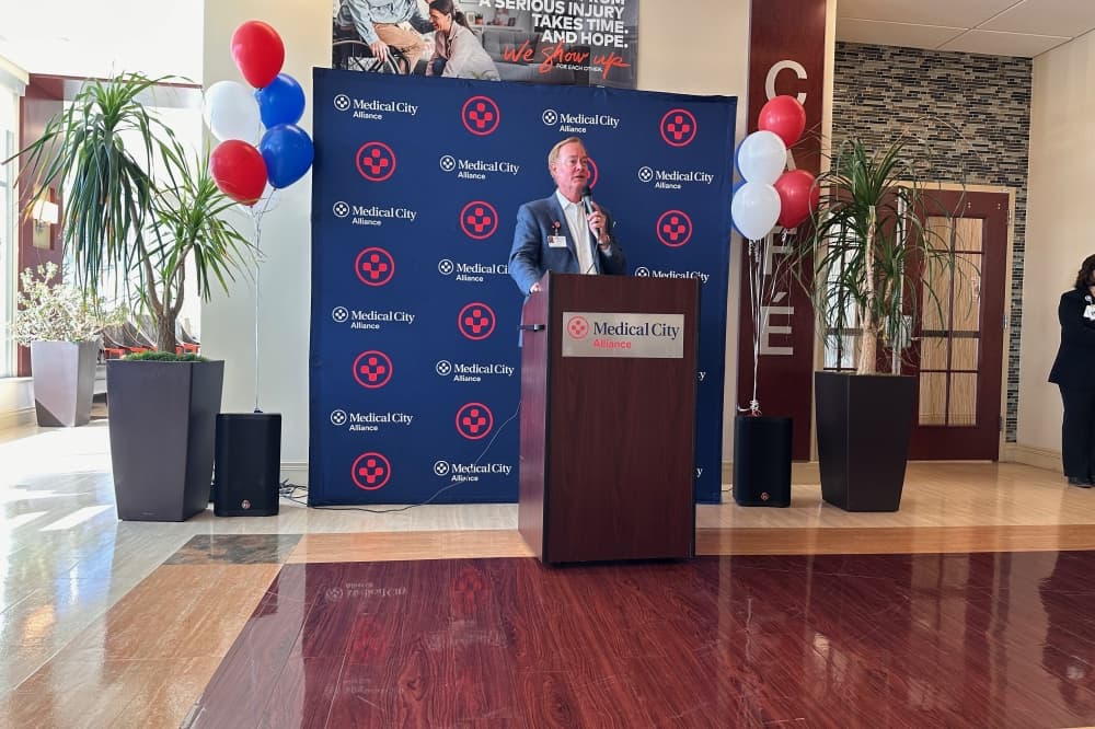 CEO Glenn Wallace speaks at podium